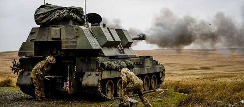 Two soldiers testing shooting a missile from a tank.