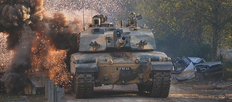 A Boxer tank being driven though smoke and sparks.